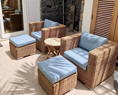 a group of wicker chairs and tables on a porch at Zweite Heimat - Townhouse Boa Vista in Sal Rei