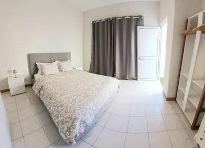 a white bedroom with a bed and a window at Flat Mindelo Deluxe 30 in Mindelo