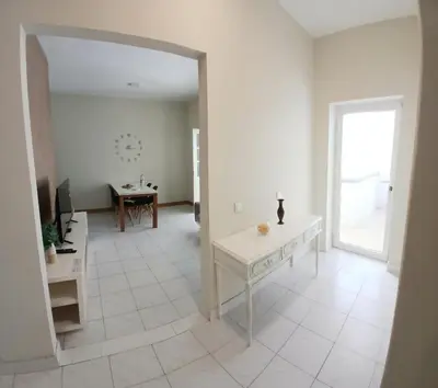 a white living room with a table and a mirror at Flat Mindelo Deluxe 30 in Mindelo