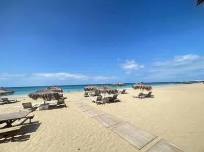 a beach with chairs and umbrellas and the ocean at La Piazza in Santa Maria