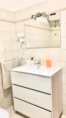 a bathroom with a white sink and a mirror at Flor de Sal Apartment in Santa Maria