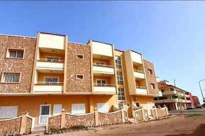 an apartment building with a fence in front of it at Flor de Sal Apartment in Santa Maria
