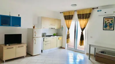 a kitchen with a refrigerator and a table in it at Flor de Sal Apartment in Santa Maria
