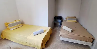two beds in a small room withermottermottermott at Mendes Family Guesthouse, and Services in Praia