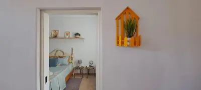 a door to a room with a bed and a plant at Mendes Family Guesthouse, and Services in Praia