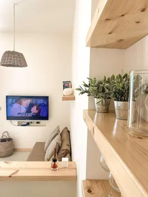 a living room with a couch and a tv on a wall at Casa da Leoa in Sal Rei