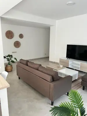 a living room with a couch and a flat screen tv at Apartamentos Baia Marginal 1 in Mindelo