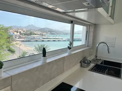 a kitchen window with a view of a harbor at Apartamentos Baia Marginal 1 in Mindelo
