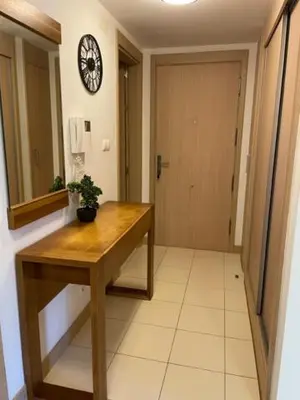a hallway with a table and a clock on a wall at Cactus Gold Vila Verde in Santa Maria