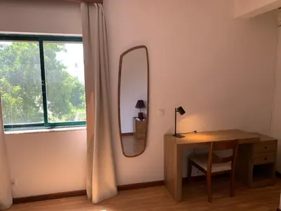 a room with a desk and a mirror on the wall at Kaza Awa - Urban Guesthouse in Praia
