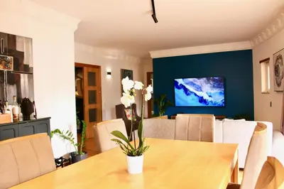 a dining room with a table and a tv at Spacious Penthouse with BBQ and Views in Praia