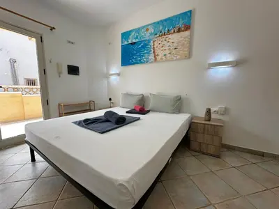 a bedroom with a large white bed in a room at Raio Do Sol - Beach front studio with city view in Santa Maria