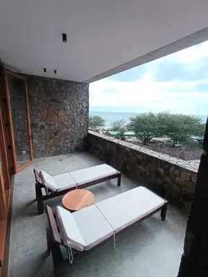 a room with two beds and a view of the ocean at São Pedro Bay in Mindelo