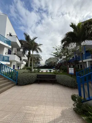 a park with a bench and palm trees and buildings at Leme Bedje - Two bedroom, Pool, WiFi & Beachfront in Santa Maria