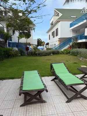 two chaise lounges with green mats on a patio at Leme Bedje - Two bedroom, Pool, WiFi & Beachfront in Santa Maria