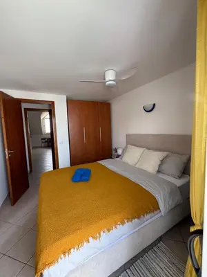 a bedroom with a large bed with a blue towel on it at Leme Bedje - Two bedroom, Pool, WiFi & Beachfront in Santa Maria