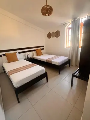 a bedroom with two beds and a window at Bed and breakfast Residencial Maravilha in Mindelo