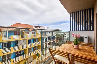 a balcony with a wooden table and chairs at Apartamentos Golfinho Dourado `Edifício Lux,s in Santa Maria