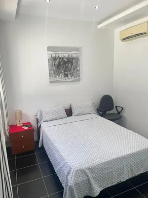 a bedroom with two twin beds and a red night stand at Apto Duarte quarto no terraço in Praia