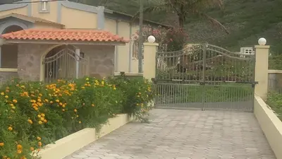 a house with a gate and a bunch of flowers at Conforto ,Natureza e Relaxamento in Carvoeiros