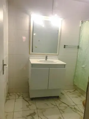 a white bathroom with a sink and a mirror at Conforto no Coração do Tarrafal in Tarrafal