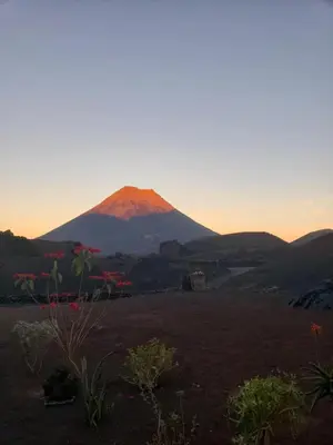 a mountain in the distance with a sunset behind it at TCHAN LOVe in Portela