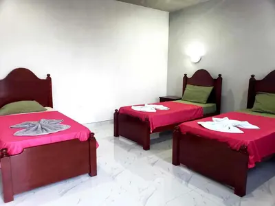 a room with two beds with red sheets and tables at TCHAN LOVe in Portela