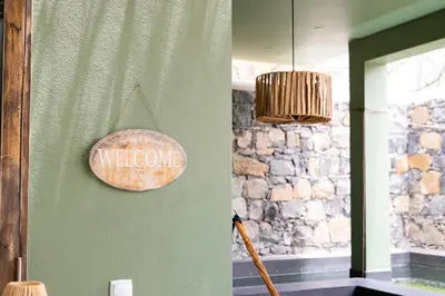 a welcome sign is hanging on a green wall at Casa Archipel - Lagedos in Ribeira Fria