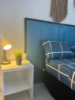 a bed with a blue headboard and a table with a lamp at Casa Cisalta N2 - 5mn Centro City in Praia