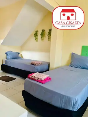 two beds in a room with a sign that reads casa casita guest house at Casa Cisalta N4 - Quarto Compartilhado in Praia