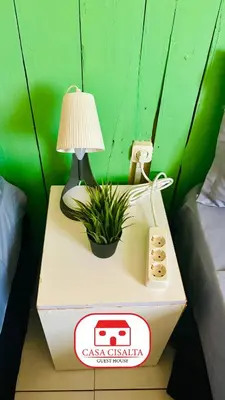 a table with a lamp and a plant on a box at Casa Cisalta N4 - Quarto Compartilhado in Praia