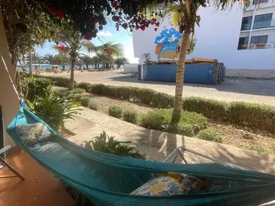 a hammock on a patio with a palm tree at Porto Antigo 2 studio 15 beach and pool in Santa Maria