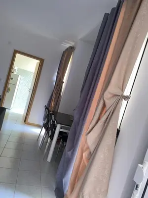 a room with curtains on a wall with a table and chairs at Apartment 3 minutes from Nelson Mandela Airport in Praia