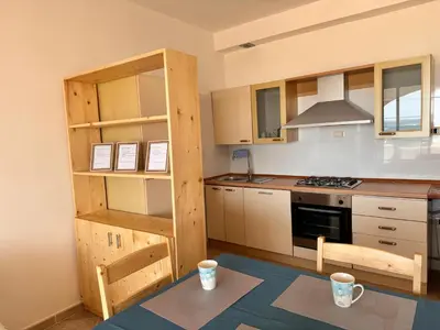 a kitchen with wooden cabinets and a stove top oven at Nautilus Cabral Sea view, free Wi-Fi in Sal Rei