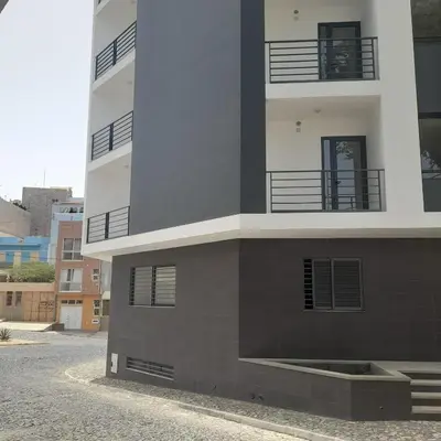 a tall building with balconies on the side of it at Rita Apartamento in Mindelo