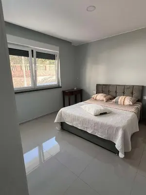 a bedroom with a large bed and two windows at LAGINHA Apartamento in Mindelo
