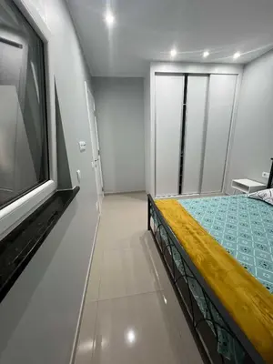 a bedroom with a bed and a flat screen tv at LAGINHA Apartamento in Mindelo