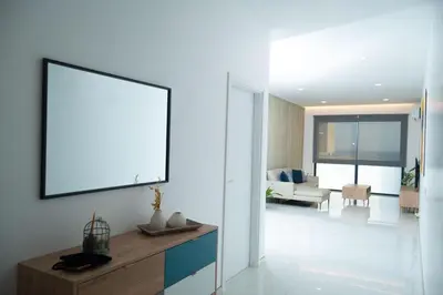 a living room with a large picture frame on the wall at Apart JC Edificio Victor in Praia