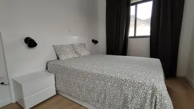 a small bedroom with a bed and a window at Sunset in Mindelo