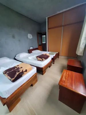 a room with three beds and a table at Puntinha d'Djô in Caculi