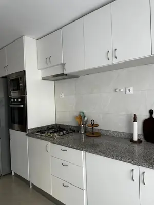 a white kitchen with white cabinets and a stove at Fanon Flat T2 in Mindelo