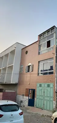 a building with green doors and a car parked in front at Tarrafal Paradise Suite in Tarrafal