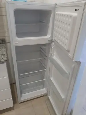 an empty refrigerator with its door open in a kitchen at Ap ACVA in Mindelo