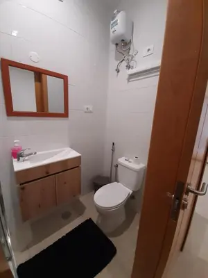 a bathroom with a toilet and a sink and a mirror at Ap ACVA in Mindelo