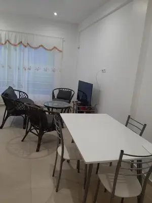 a room with a white table and chairs and a window at Ap ACVA in Mindelo