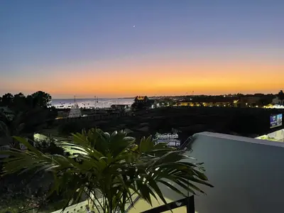 a view of the beach at sunset from a balcony at Tropical Suite 22 A in Santa Maria