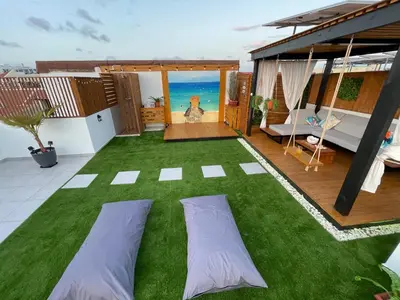 a patio with green grass and a room with the ocean at Tropical Suite 22 A in Santa Maria