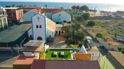 a small church with a cross on top of a town at Tropical Suite 22 A in Santa Maria