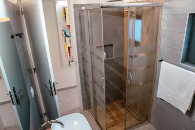 a shower with a glass door in a bathroom at Tropical Suite 22 B in Santa Maria