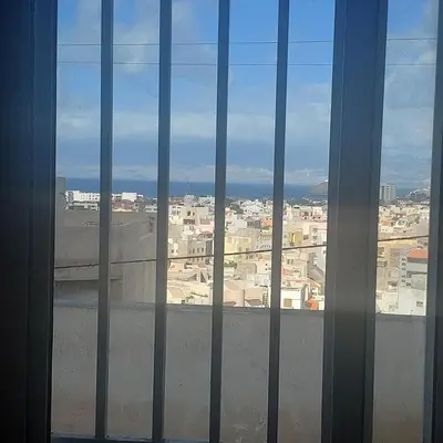 a view of a city from a window with bars at Oia Mindelo Chambre d'hotes in Mindelo